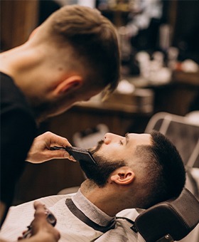 Professional men's grooming service featuring detailed beard contouring and structured facial hair styling