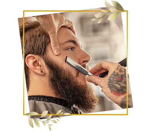 Man receiving classic straight razor shave with careful beard shaping as part of men’s grooming service.